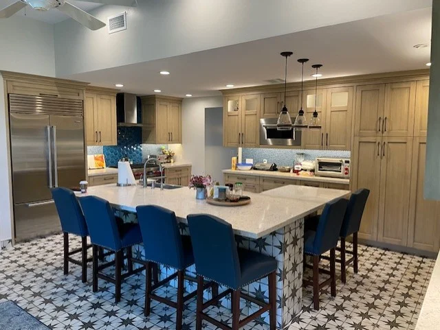 Kitchen with natural wood cabinets, quartz countertops, blue tile backsplash, and blue upholstered island seating