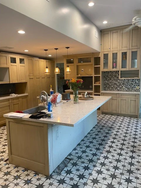 Kitchen with light wood cabinets, quartz countertops, geometric tile floor, and pendant lighting